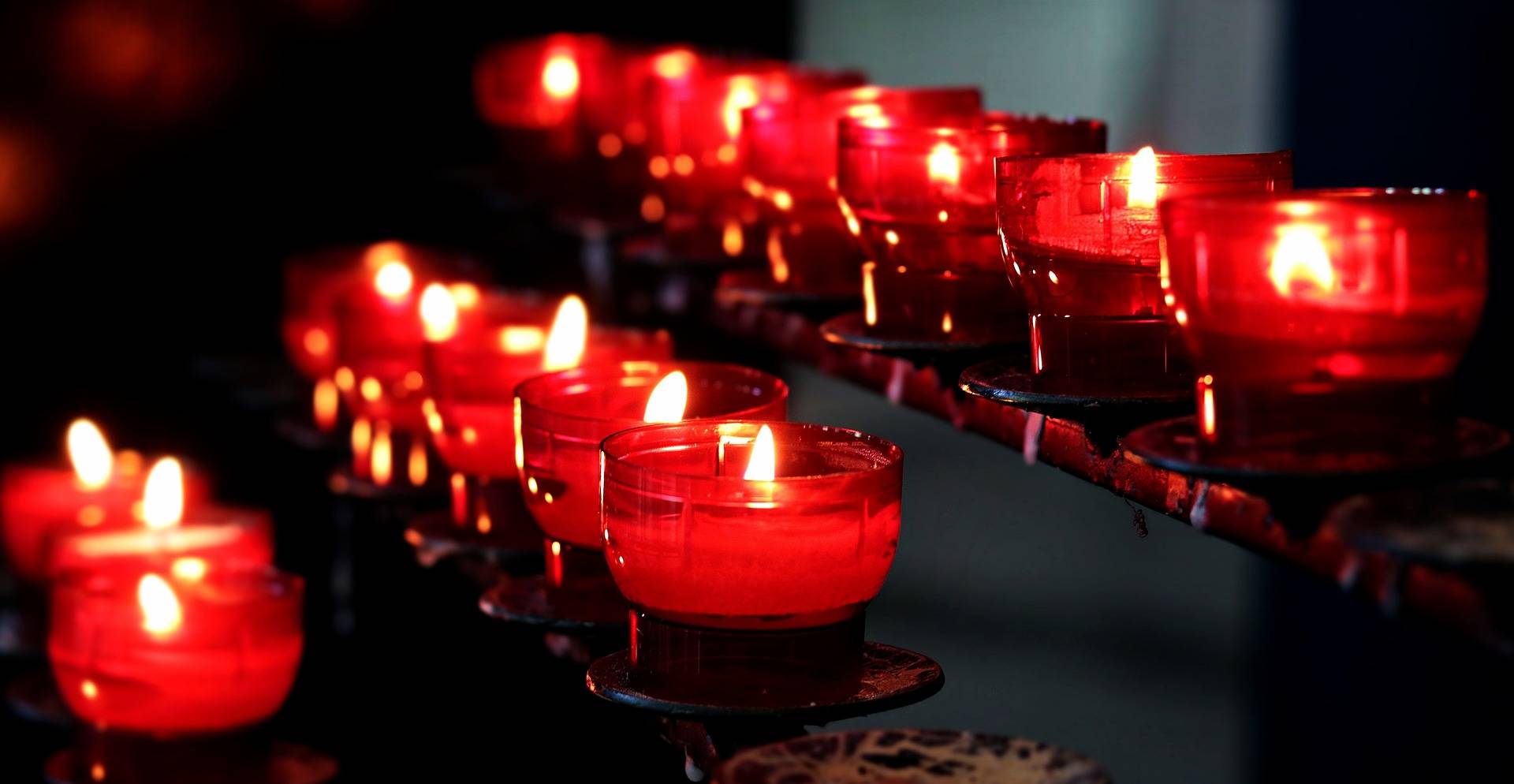 Quelle: pixabay.com/de/users/noname_13-2364555/, https://pixabay.com/de/photos/kerzen-kirche-lichter-gebet-2628473/ Rote Kerzen brennen in der Kirche